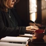 A person reading an email newsletter on a phone over morning coffee