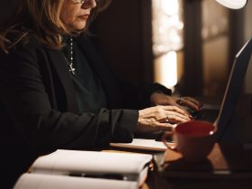 A person reading an email newsletter on a phone over morning coffee